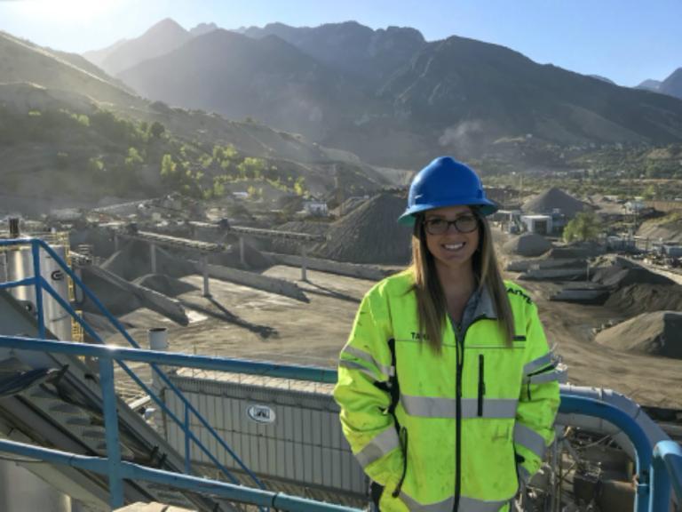 Alumna Danielle Taran on an educational trip to Salt Lake City, Utah. Danielle currently works for Granite Construction. One of her favorite things about the aggregate industry is that the locations are often in major cities, and she doesn't have to give up city life for her career. During this trip, she visited about 6 quarries all nestled along the mountains surrounding the city. This photo shoes the view from the top of the asphalt silos where you could see most of the plant and the adjoining quarry.