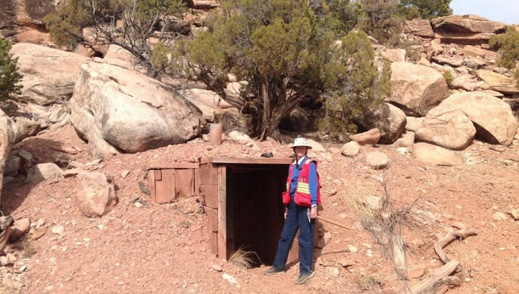 Isabel Barton standing in front of a mine entrance