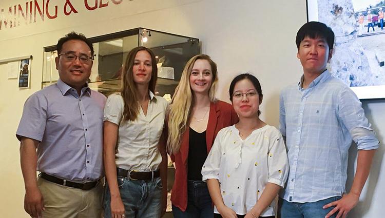 Associate professor Jaeheon Lee stands with four graduate students in a classroom.